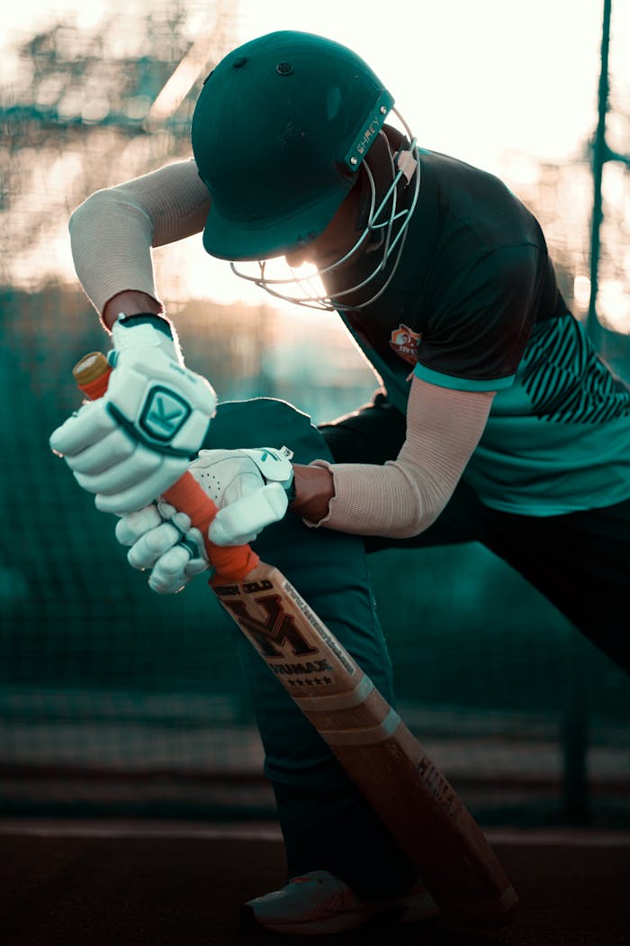 Home Side profile of a cricketer practicing batting technique at sunset.